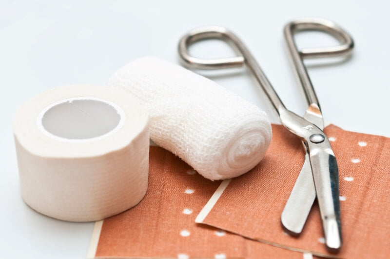 The picture shows different types of bandage materials and a pair of bandage scissors - buy bandage materials now!
